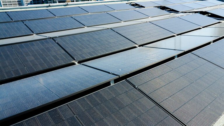 Darstellung einer PV-Anlage auf einem Flachdach, aufgestellt in zwei Winkeln für die Aufnahme der Ost-West-Sonneneinstrahlung.