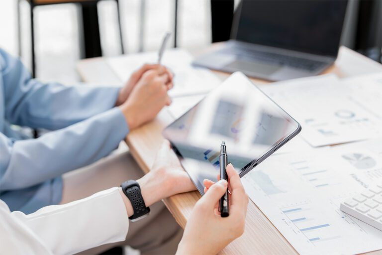 Zwei Personen, die vor einem Tablet sitzen und Statistiken zum Energieverbrauch angucken.