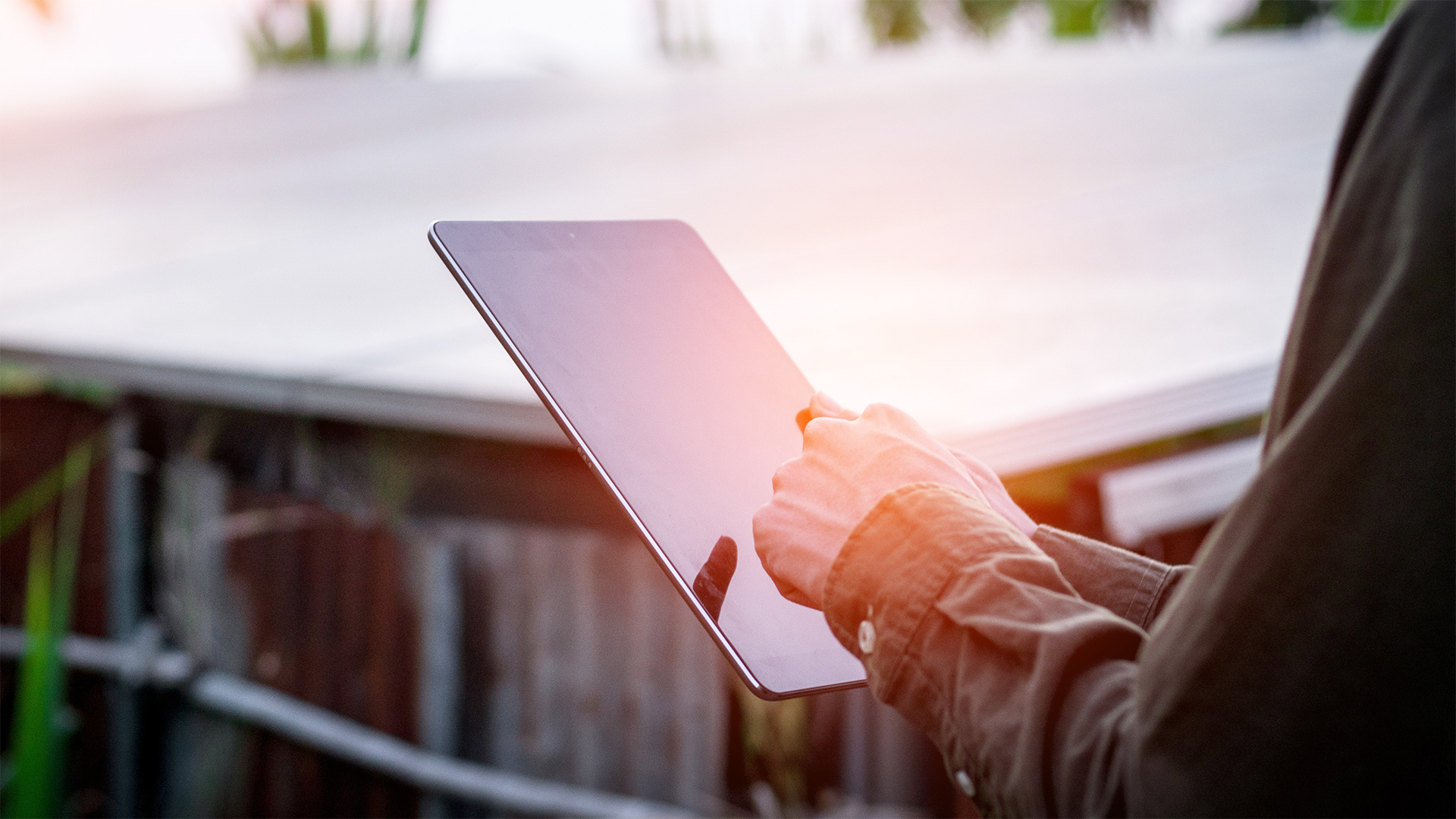Darstellung einer Person, die im Freien auf einem Tablet tippt.