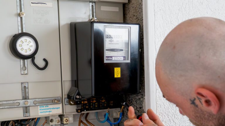 Darstellung eines Elektrikers an einem Stromzähler.