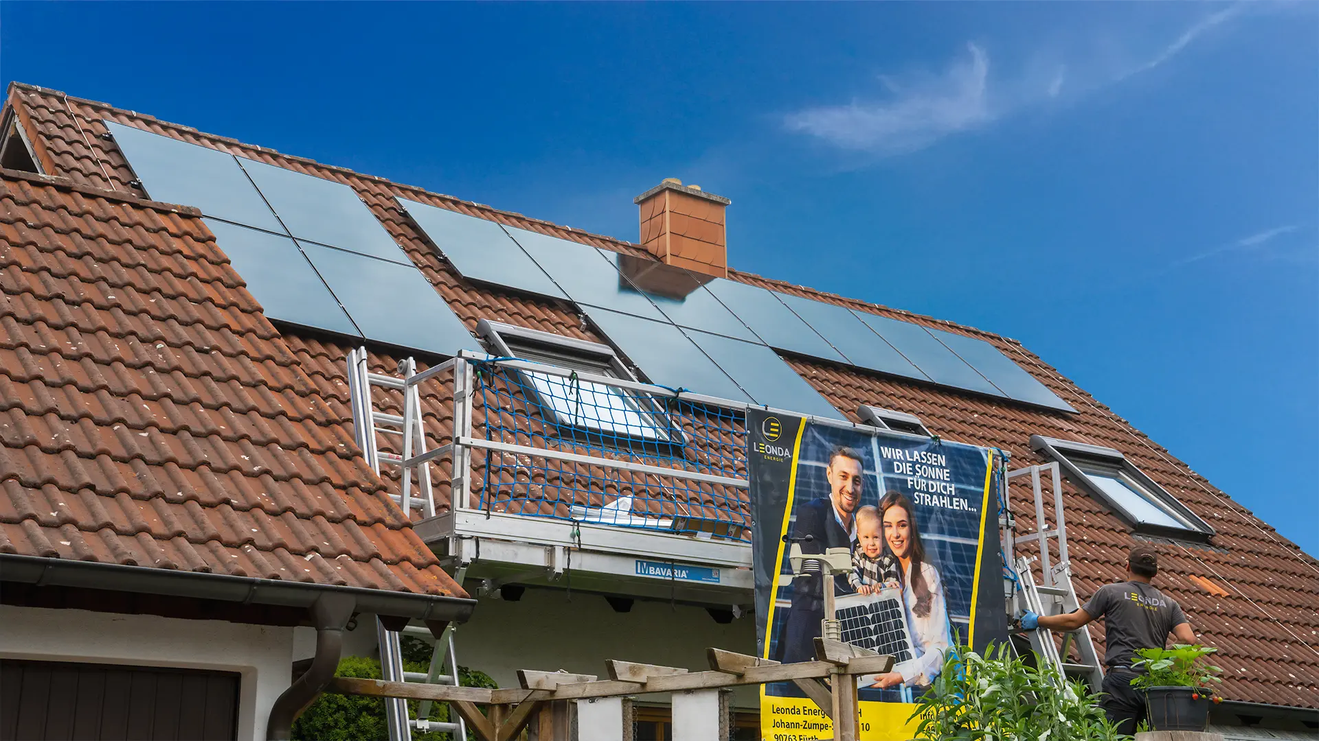 Darstellung einer PV-Modul-Installation auf einem Einfamilienhaus mit blauem Himmel.