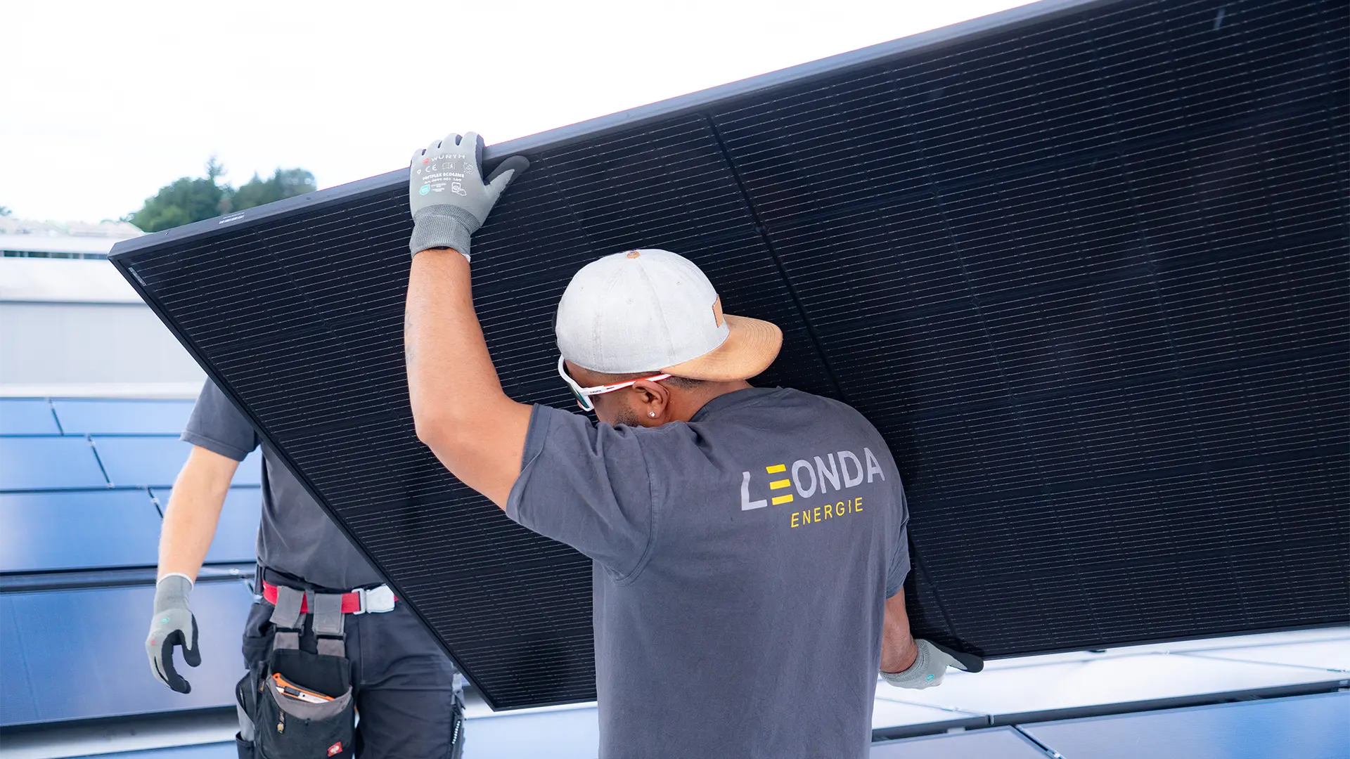 Abbildung eines Mitarbeiters von LEONDA mit einem Photovoltaikmodula auf der Schulter.